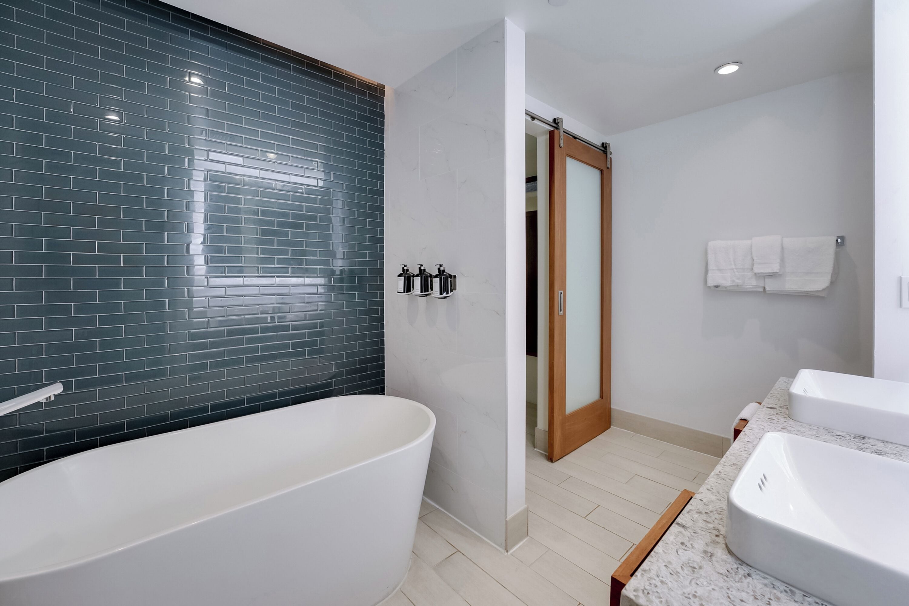 Une salle de bain moderne avec une baignoire sur pieds, un lavabo blanc et un porte-serviettes.