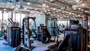 A gym with various exercise equipment, including treadmills and weight machines, and a ceiling with hanging lights. - Stayshort - Studio in Business bay Sleeps 2 With City Views (Dubai)