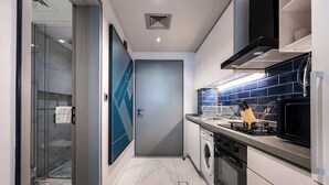 A modern kitchen with a built-in oven, microwave, and stainless steel appliances. - Stayshort - Studio in Business bay Sleeps 2 With City Views (Dubai)