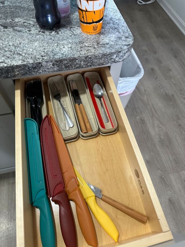 A kitchen drawer with various utensils, including knives, a spoon, and a spatula. - Boutique Motel in Akron (Akron)
