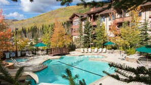 A resort with a large pool, lounge chairs, and a mountainous backdrop. - Powder Stash (with AC unit!) by Cottonwood Lodging (Solitude)