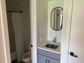 Une salle de bain avec des toilettes, un lavabo et un miroir.