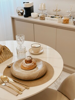 A dining table with a dessert plate, a cup, and cutlery. - Mida Luxury Apartment (Naples)