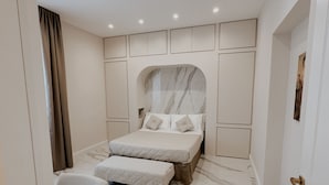 Un dormitorio moderno con una cama grande, una mesita de noche y una silla.
