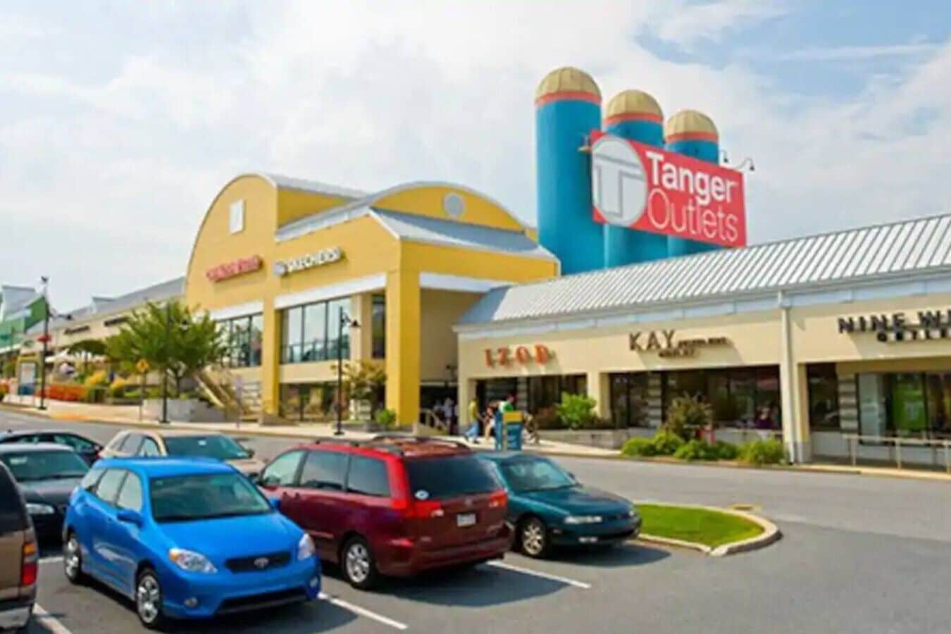 Ein Einkaufszentrum mit einem Schild von Tanger Outlets, einem Kay-Geschäft und einem Geschäft mit einer Größe von 1200.