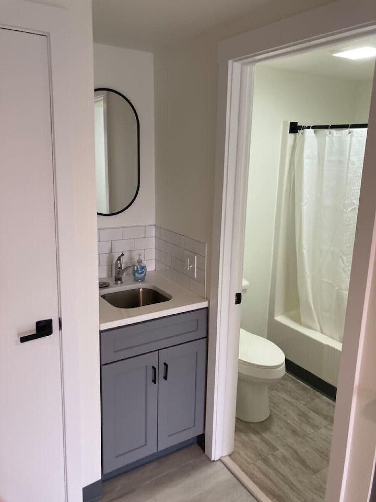 Un baño con inodoro, lavamanos y zona de ducha.