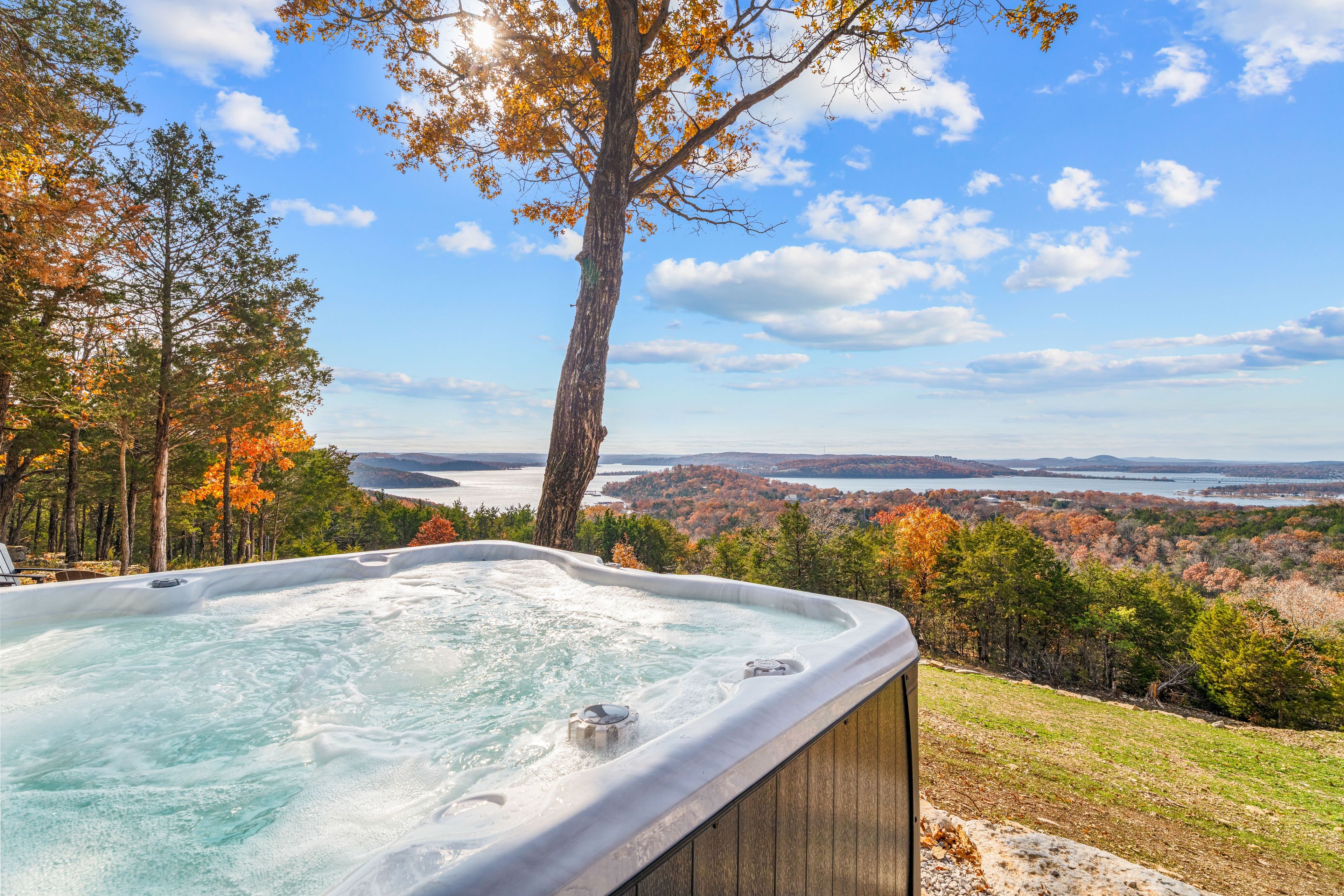 A hot tub with a clear view of a lake and forest in the background.
