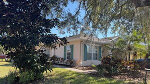 A single-story house with a front yard, a driveway, and a lawn. - Welcome to resort style living in Kissimmee! (Kissimmee)