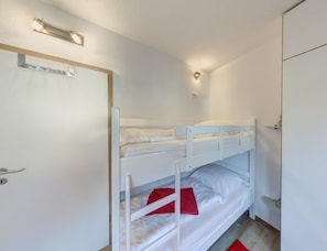 A bunk bed room with a door, a light fixture, and a small shelf. - Grosszugige Ferienwohnung fur bis zu 9 Personen (Butjadingen)