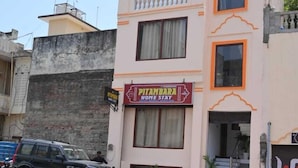 A two-story building with a sign for 'PITAMBAHA HOME STAY'. - Pitambara Homestay (Faizabad)