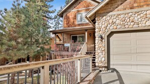 A two-story house with a stone exterior and a wooden deck. - Brownie Resort Retreat | Walk-to-Ski Snow Summit Duplex Getaway (Big Bear Lake)