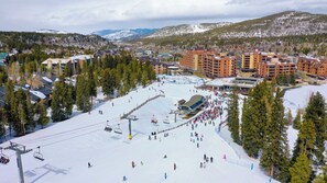 A ski resort with a ski lift, buildings, and snow-covered mountains in the background. - River Mountain Lodge Downtown Condo - Ski In, Mountain Views, Pool/Hot Tub (Breckenridge)