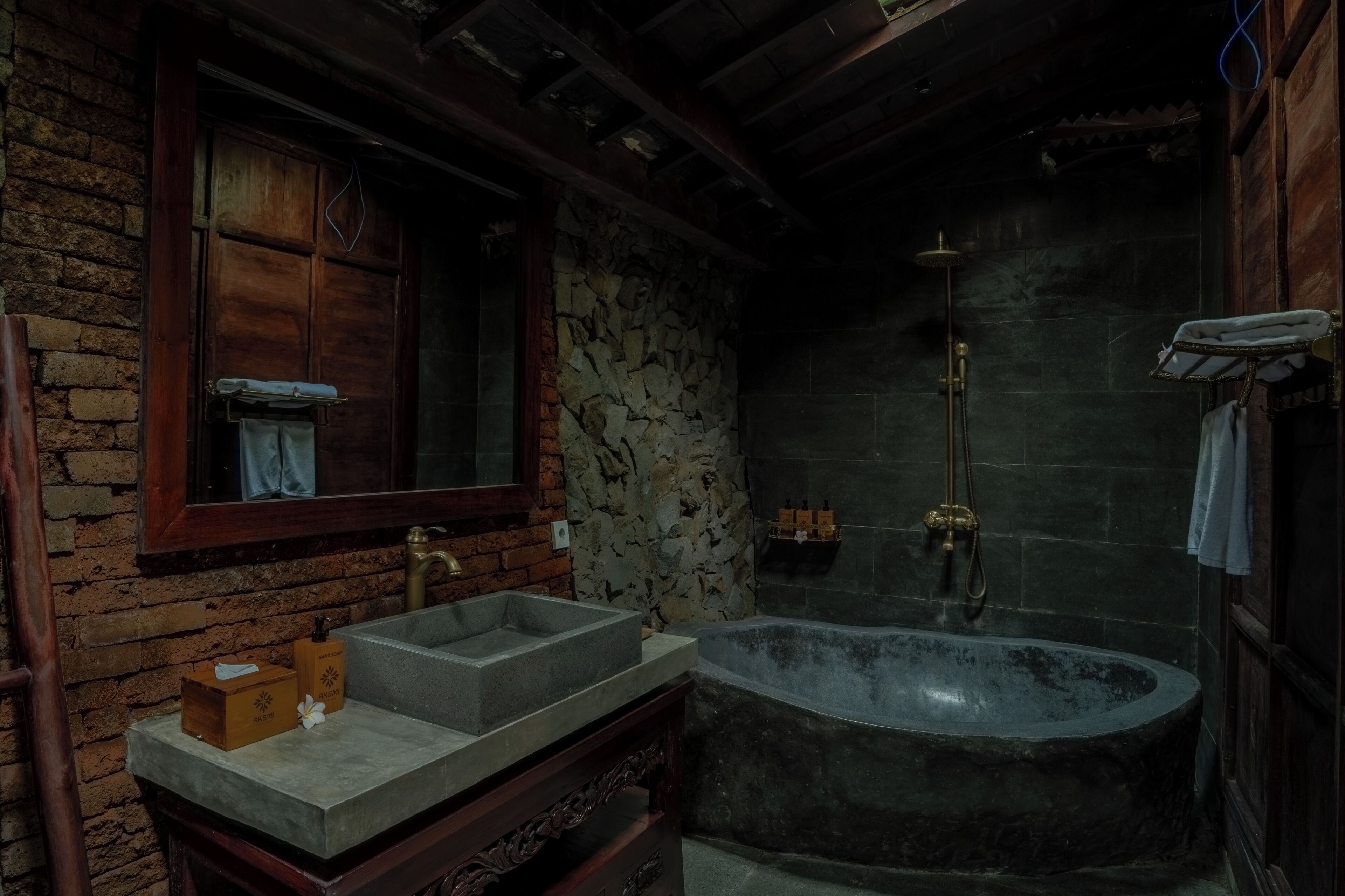 Une salle de bain avec un lavabo en pierre, une baignoire et une douche.