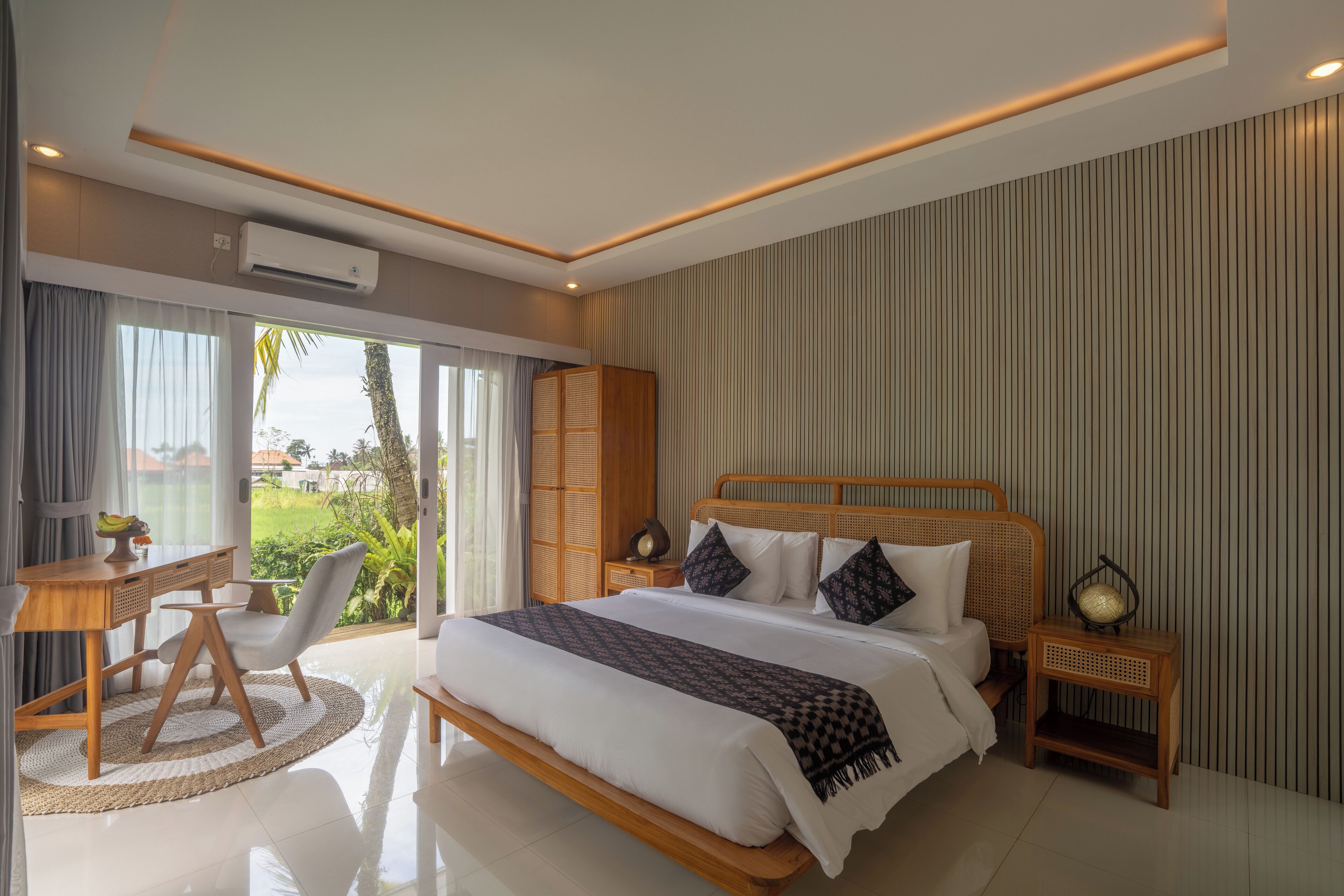 A modern bedroom with a large bed, a desk, and a chair.