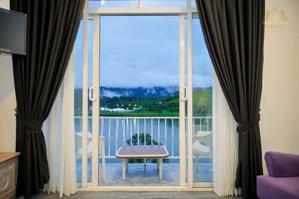 Une chambre avec un balcon, une table et une chaise.