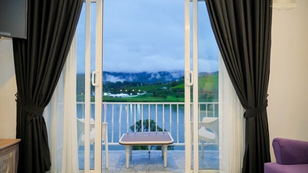 A room with a balcony, a table, and a chair.