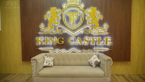 A room with a sofa and a wall displaying the logo and name "KING CASTLE".