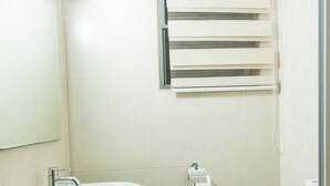 A bathroom with a sink, toilet, and towel rack. - Spacious Two Bedroom Luxury at Avant Garde (Accra)