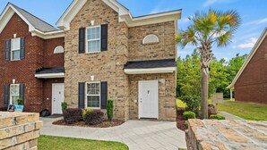 A two-story residential building with a brick facade, white doors, and shutters. - Charming 3-bedroom, 2.5 bath townhome. Largest with accommodations in Florence. (Florence)