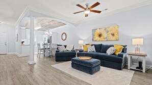 A spacious living room with a ceiling fan, a large sofa set, a coffee table, and a dining area in the background. - Charming 3-bedroom, 2.5 bath townhome. Largest with accommodations in Florence. (Florence)