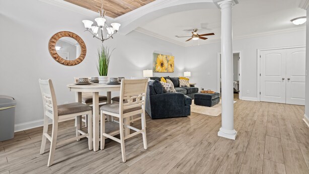 A dining area with a wooden table and chairs, a chandelier, and a large mirror on the wall. - Charming 3-bedroom, 2.5 bath townhome. Largest with accommodations in Florence. (Florence)