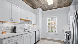 A modern kitchen with white cabinets, a built-in oven, and a window with blinds. - Charming 3-bedroom, 2.5 bath townhome. Largest with accommodations in Florence. (Florence)