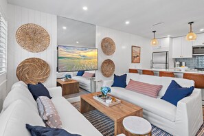 A modern living room with white sofas, a coffee table, and decorative woven baskets. - New to 30A! Freshly Renovated, Walk to Seaside, Pool, Easy Beach Access (Santa Rosa Beach)