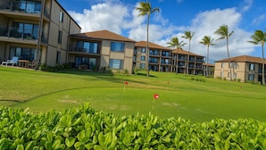 Un terrain de golf avec un drapeau portant le numéro « 19 », et en arrière-plan, un bâtiment doté de nombreux balcons et fenêtres.