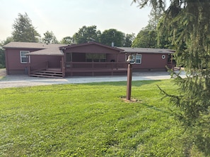 Een tweelaags huis met een veranda en een klokkentoren.