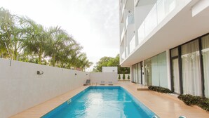 Une piscine intérieure rectangulaire à l’eau d’un bleu cristallin, entourée d’une terrasse carrelée.