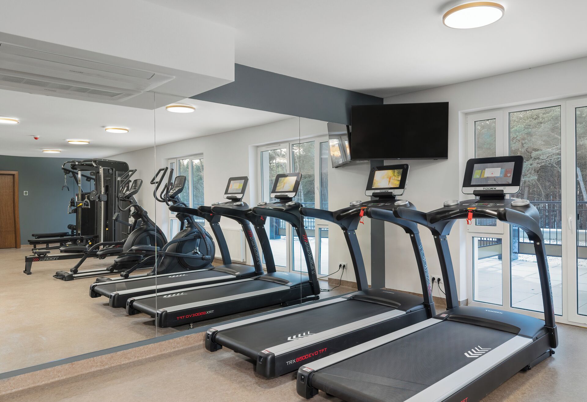 A gym with treadmills, exercise bikes, and weight machines.