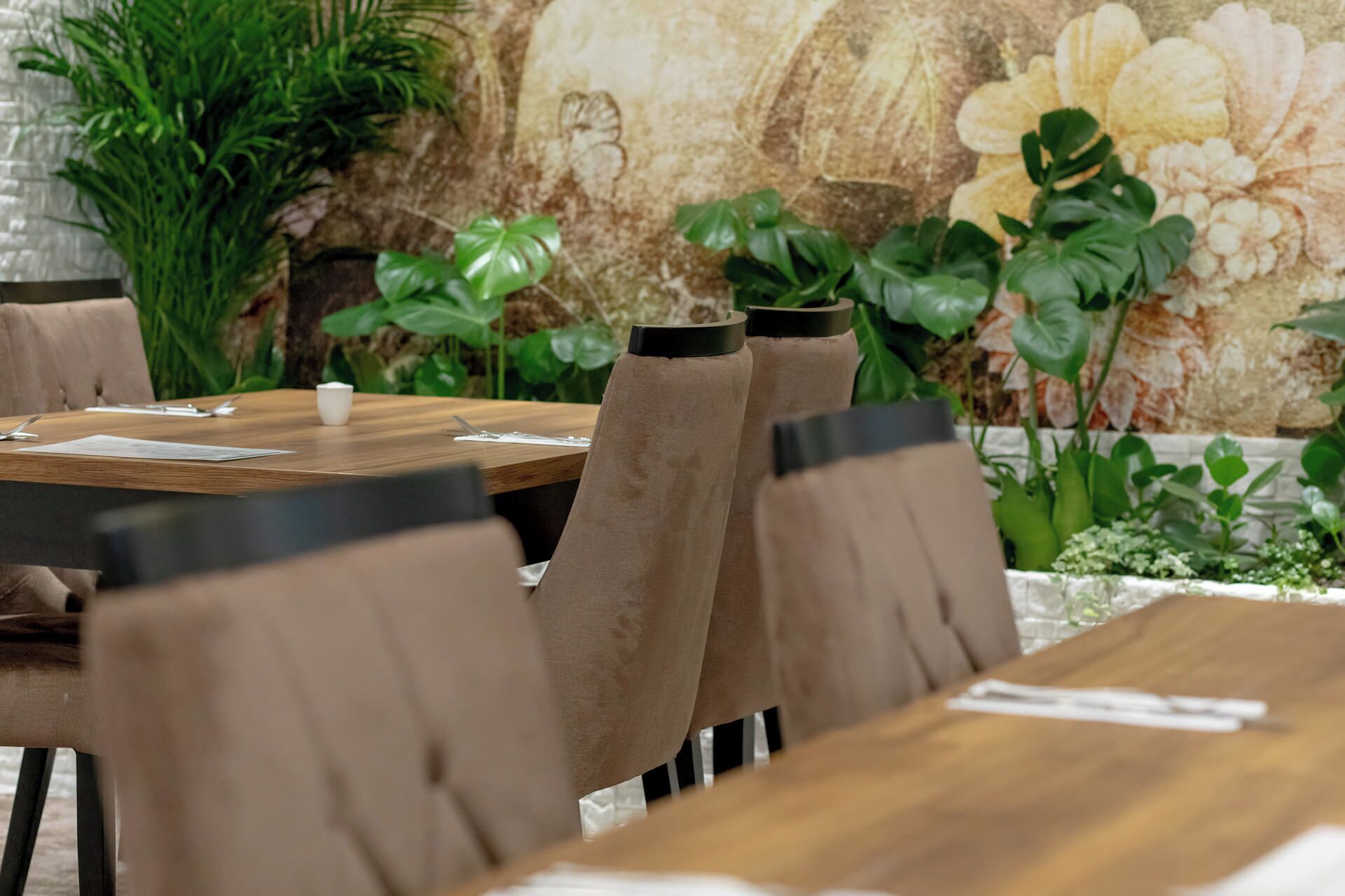 A dining area with a wooden table and brown upholstered chairs.