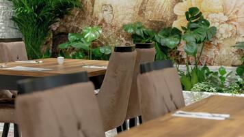 A dining area with a wooden table and brown upholstered chairs.