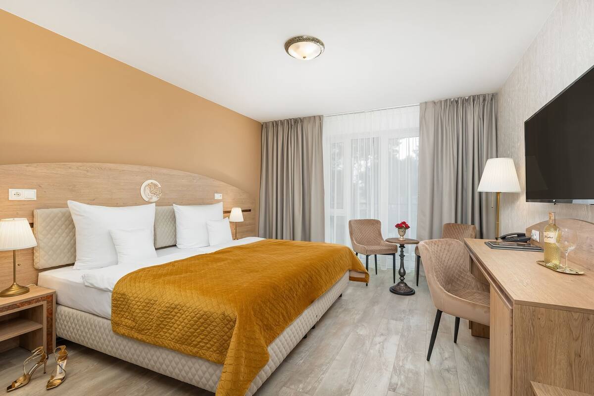 Une chambre d’hôtel équipée d’un lit, d’un bureau, d’une chaise et d’un téléviseur.