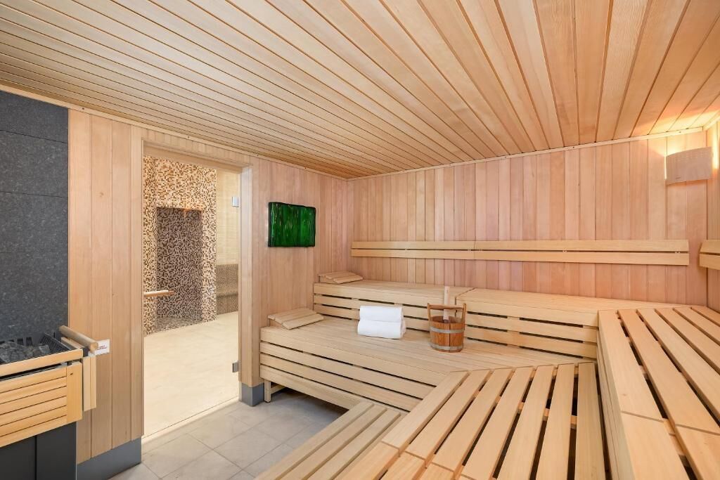 Een sauna met houten banken en een stenen muur.