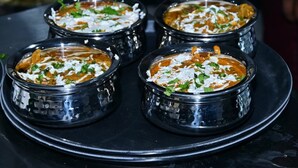 Quatro porções de curry em um prato preto.