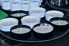 Una bandeja con varios recipientes que contienen un plato cremoso, posiblemente una salsa o crema para untar.