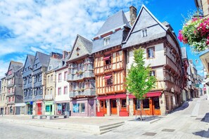 A row of traditional European buildings with multiple stories, balconies, and a clear sky. - Charming house in the heart of the village (Plougasnou)