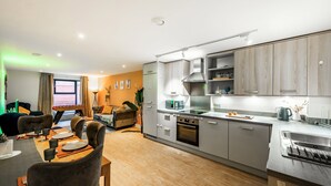 A modern kitchen with grey cabinets, a built-in oven, and a stainless steel sink. - Huge Digbeth Apt, Sleeps 8, 5bed, Free Parking. (Birmingham)