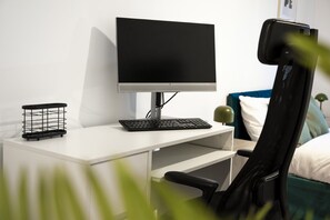 A modern workspace with a computer, keyboard, and chair. - Huge Digbeth Apt, Sleeps 8, 5bed, Free Parking. (Birmingham)