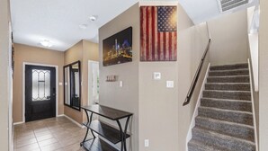A hallway with a dark wooden bench, a door with a glass panel, and a staircase with carpeted steps. - Spacious 4-bedroom house in charming Jarrell with AC (Jarrell)