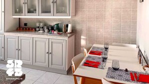 A modern kitchen with grey cabinets, a dining area with a table set for two, and a 'Cuisine' sign on the wall. - Elegant apartment for 6 people. Private elevator and large terrace. Milan. (Milano)