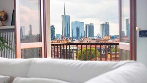A modern living room with a large window overlooking a city skyline. - Elegant apartment for 6 people. Private elevator and large terrace. Milan. (Milano)
