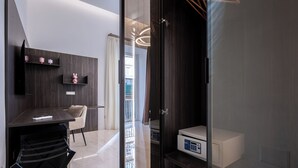 Une pièce moderne avec un mur en bois foncé, une chaise blanche, un bureau et une porte en verre donnant sur un balcon.