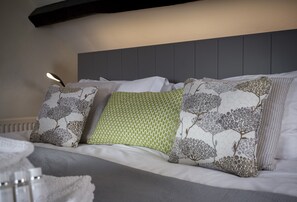 A neatly made bed with patterned pillows and a bedside lamp. - A place you'll wish you had booked for longer (Painswick)