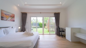 A bedroom with a bed, a desk, and a view of the outdoors. - TropicalFamilyVilla w Pool&Garden ML103 (Hua Hin)