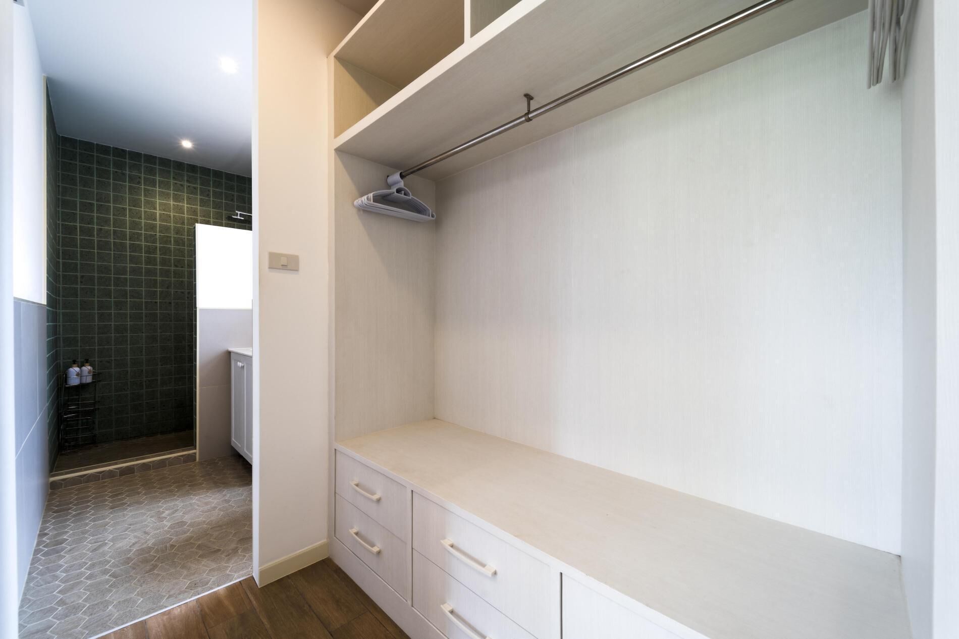 A modern bathroom with a shower, a toilet, and a vanity with drawers.