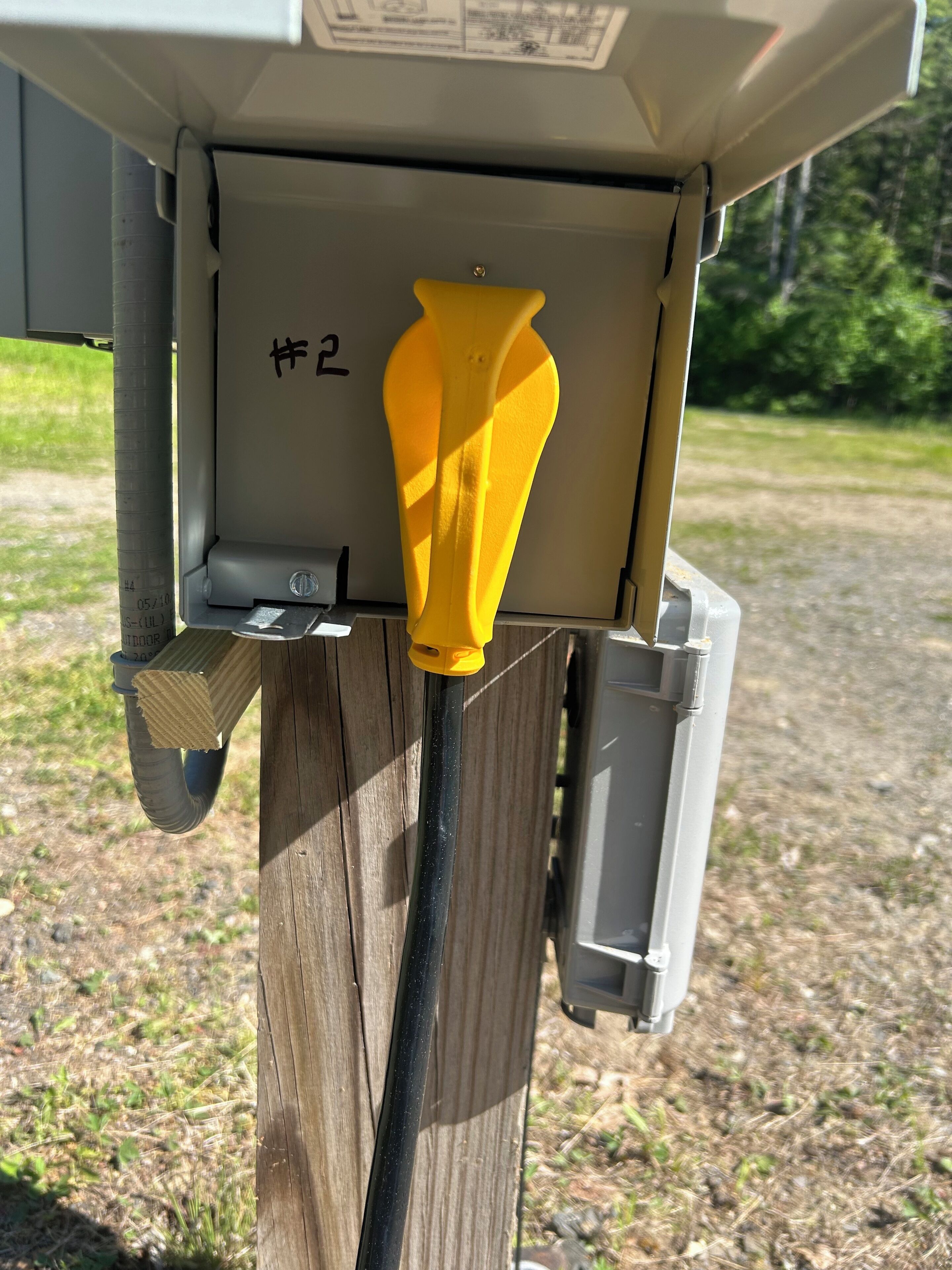 En servicebox med ett gult handtag och en etikett märkt med siffran "2".
