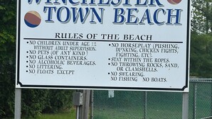 A sign listing rules for Winchester Town Beach, including no children under 12 without adult supervision, no pets, no glass containers, no alcoholic beverages, no littering, no horseplay, and no boats.