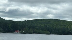 A beach with a lifeguard tower and a forested hill in the background.
